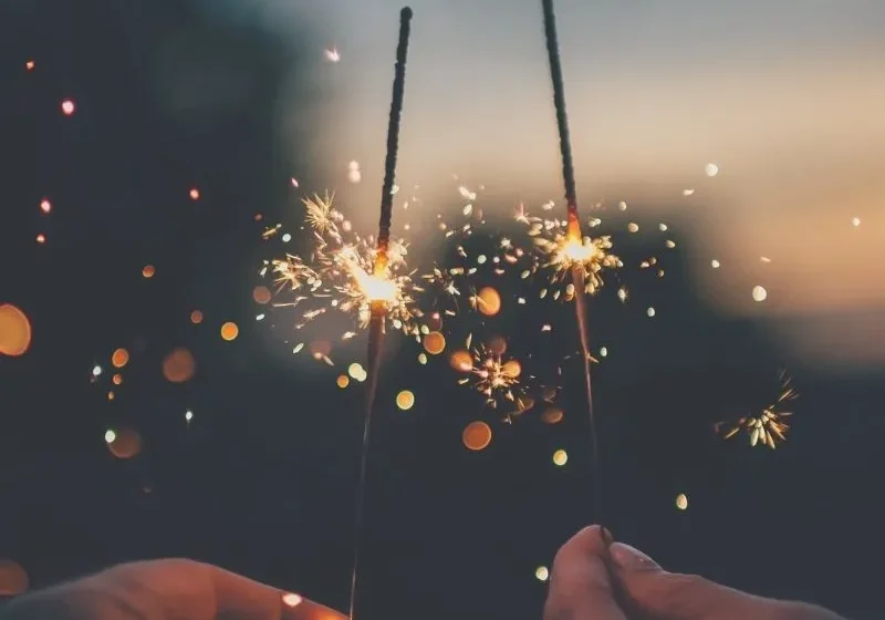 two hands holding fireworks for celebration