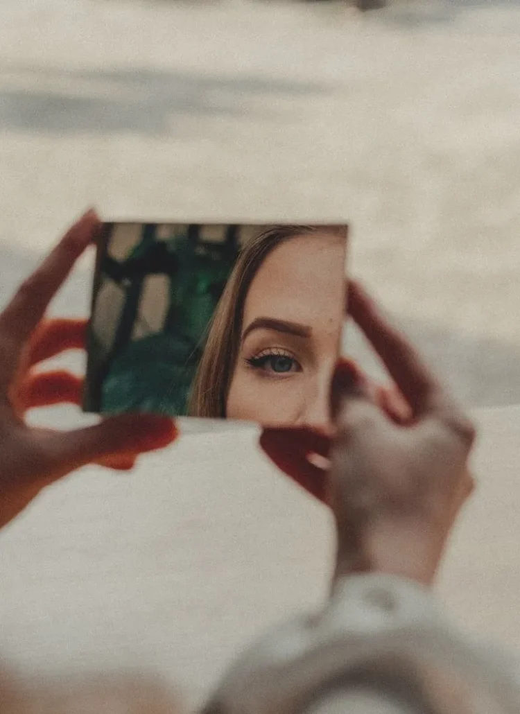 woman looking at herself in the mirror to discover who she is