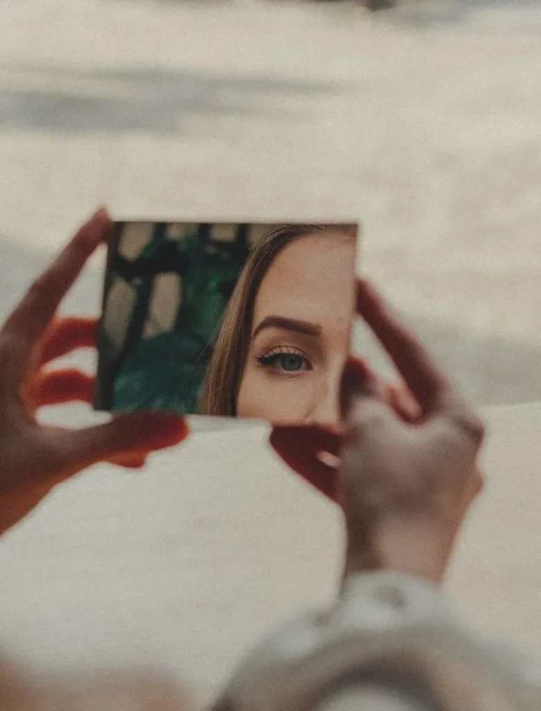 woman looking at herself in the mirror to discover who she is