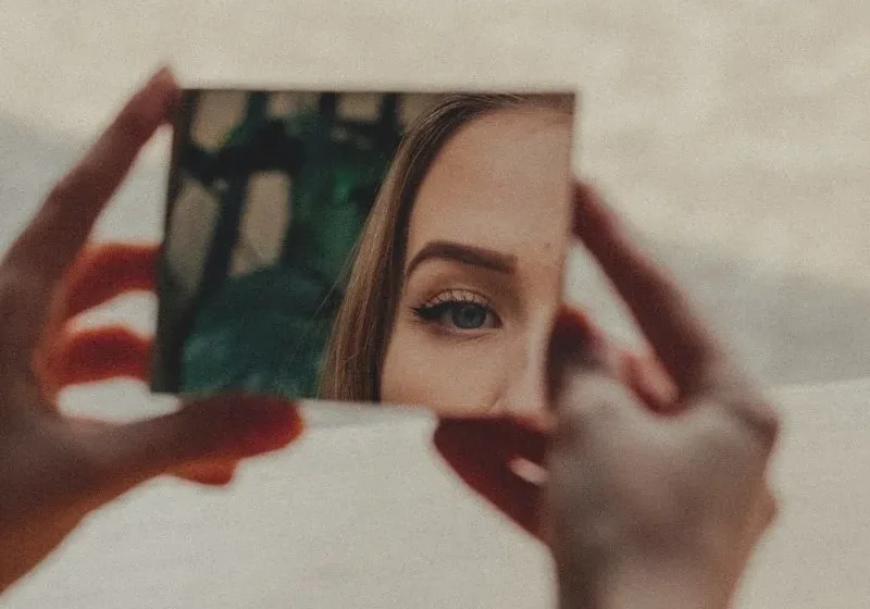 woman looking at herself in the mirror to discover who she is