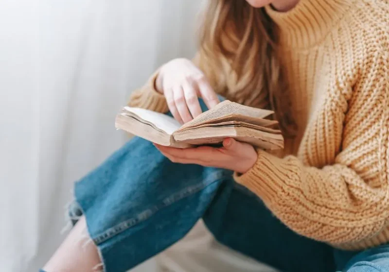 woman reading instead of scrolling on her phone as an alternative to improve mental health and be more mindful in the present moment