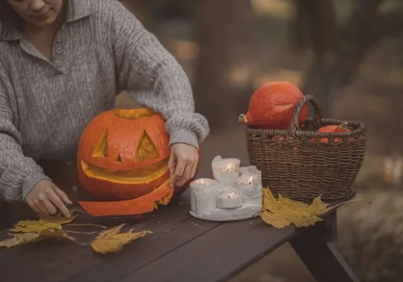 woman doing autumn activities, carving a pumpkin