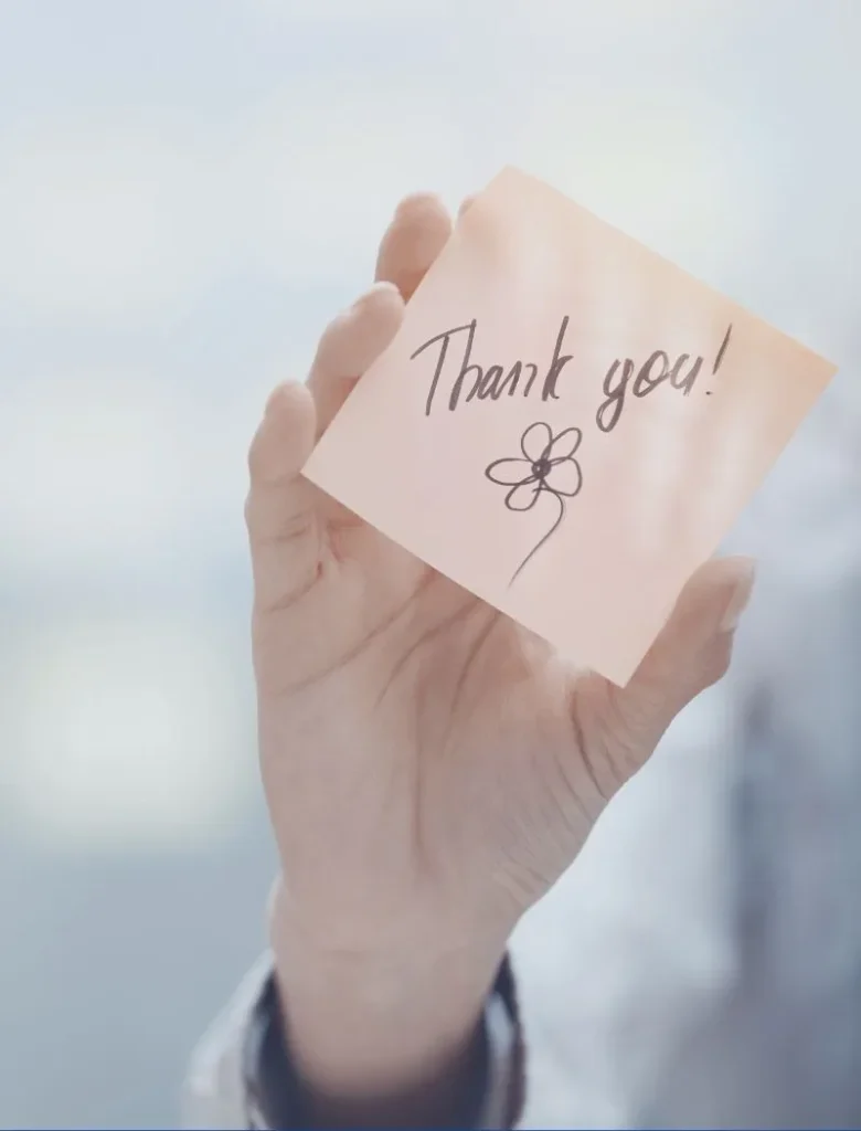 hand holding a thank you post-it note expressing gratitude and appreciation