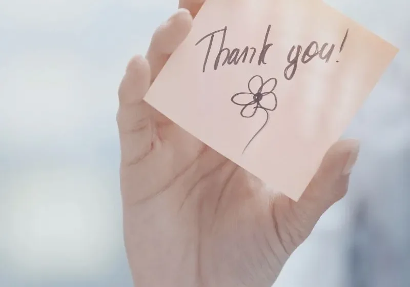hand holding a thank you post-it note expressing gratitude and appreciation