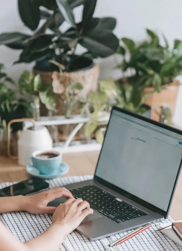 woman staying productive and working on her laptop with coffee on the side
