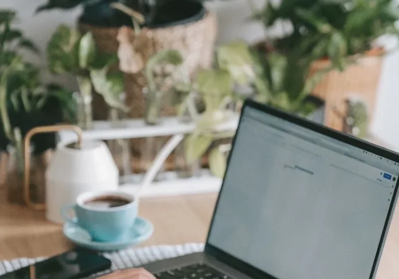 woman staying productive and working on her laptop with coffee on the side