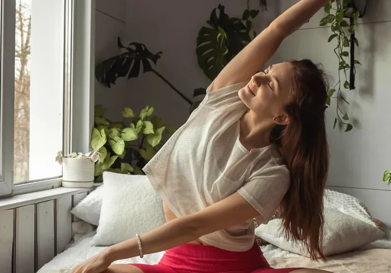 woman stretching on her bed as part of daily morning habit and routine