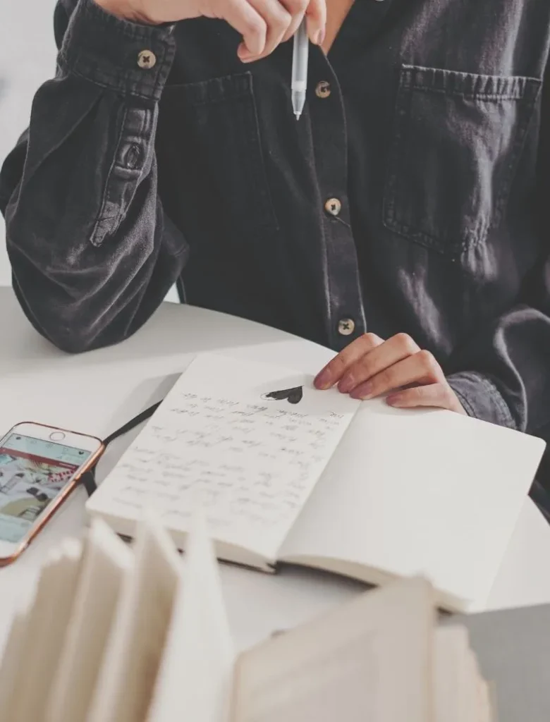 woman writing end of day journal prompts