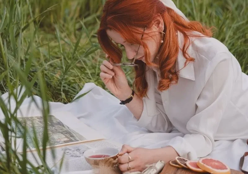 woman with red hair wearing having picnic