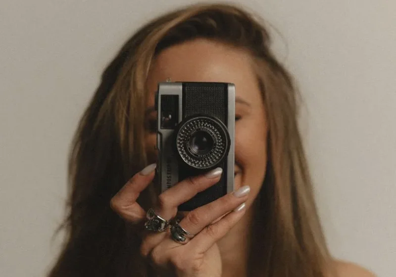 woman with a camera in front of her face