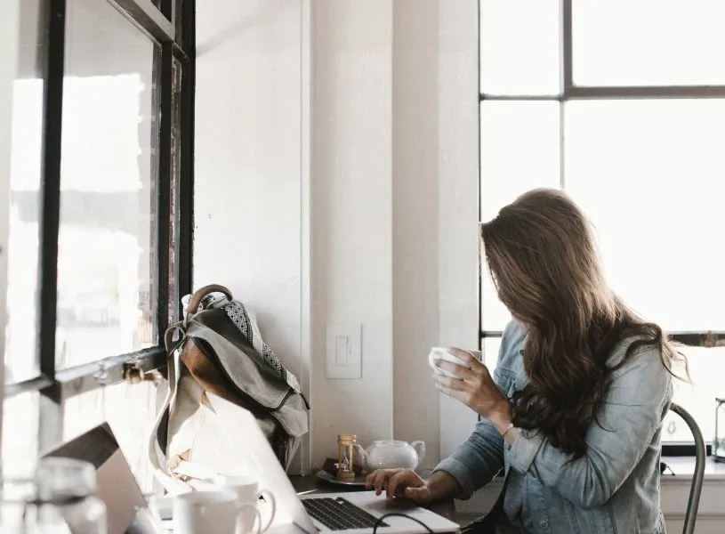 woman having coffee and making plans using her laptop