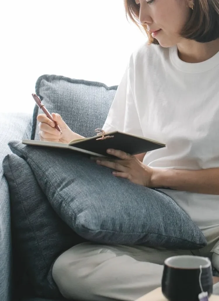 woman doing a midweek check-in in her journal using midweek journal prompts