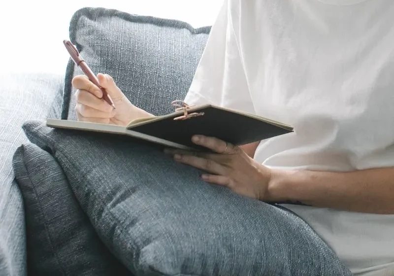 woman doing a midweek check-in in her journal using midweek journal prompts