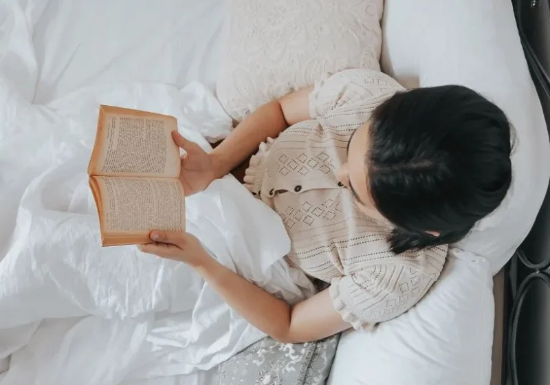 woman reading a book in bed