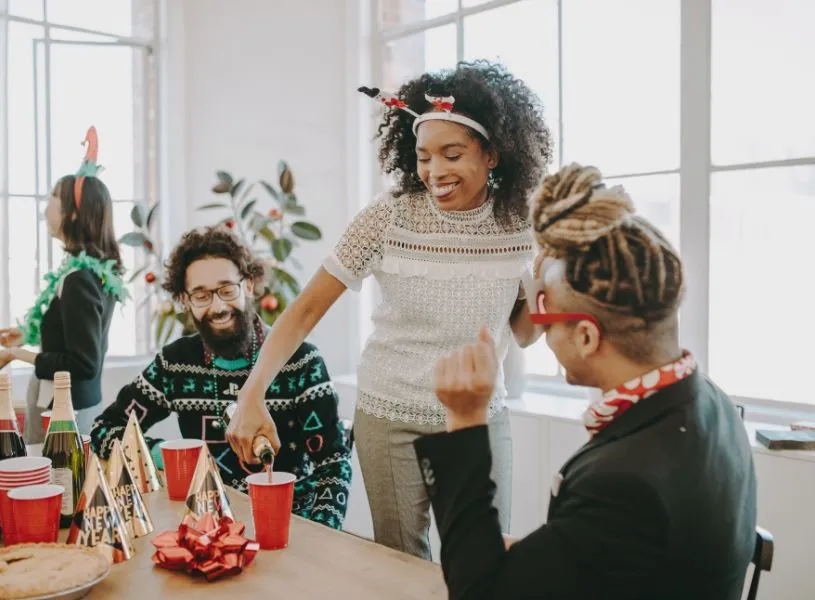 woman pouring drinks and celebrating the holiday season