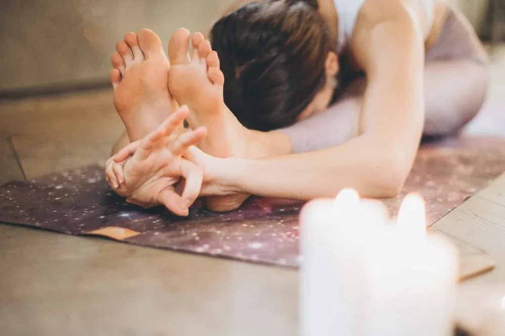 woman practicing yoga and meditation to ground herself as part of her morning routine