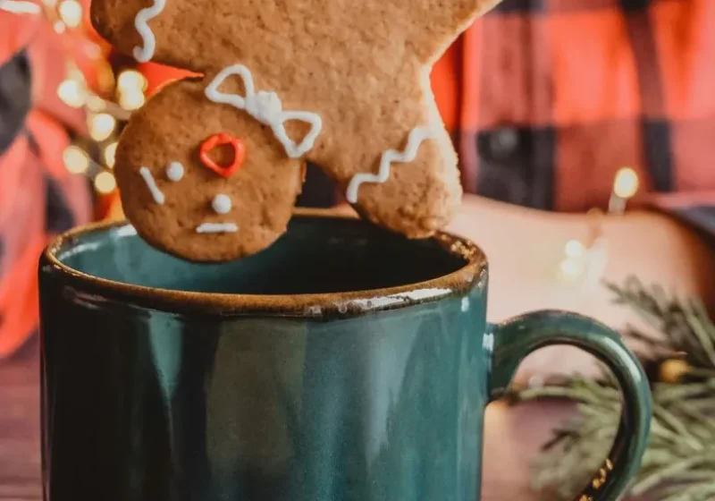 a gingerbread man being dipped inside a cup
