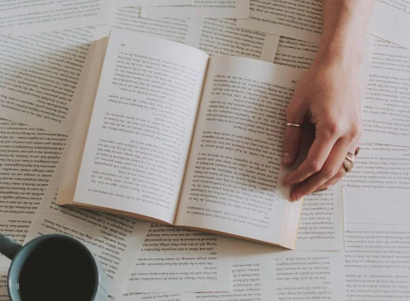 woman hand with rings placed on top of a book