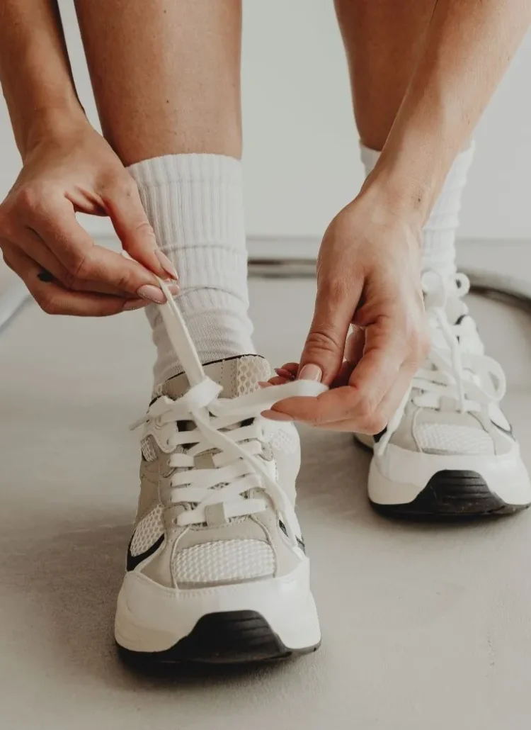 woman tying her shoe laces ready to work hard and hustle