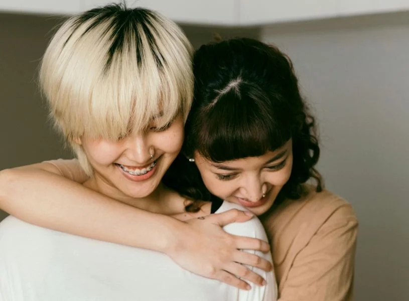 two woman hugging each other