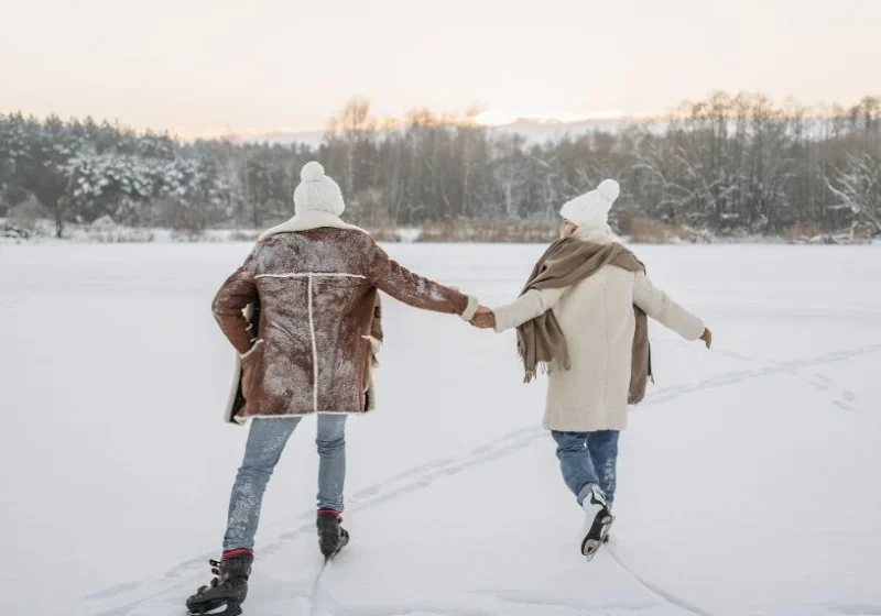 man and woman walking in the snow together