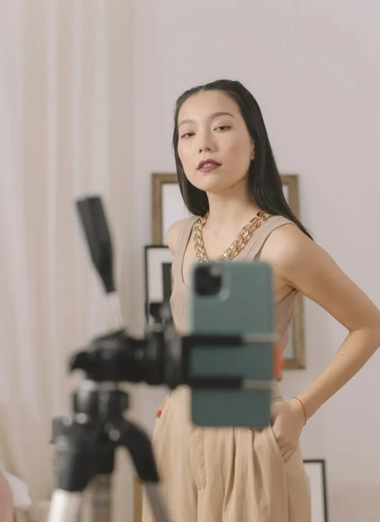 asian woman standing in front of a phone held by a tripod