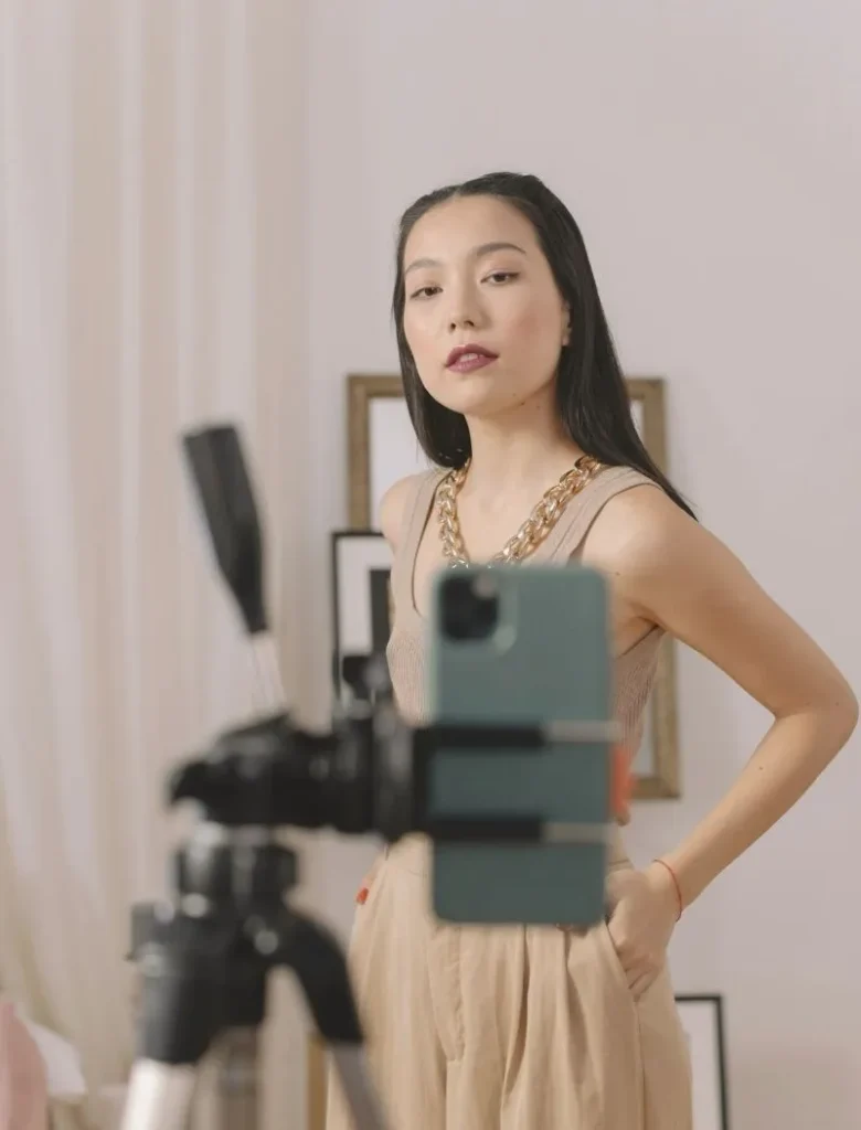 asian woman standing in front of a phone held by a tripod
