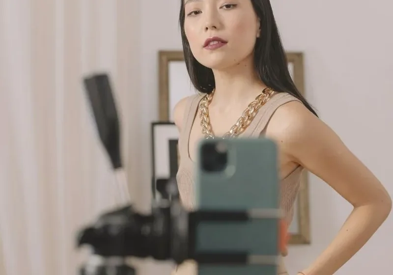 asian woman standing in front of a phone held by a tripod