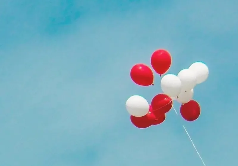 red and white balloons floating in the sky