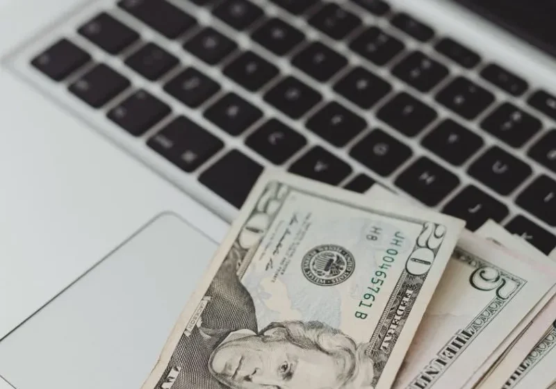 dollar bills on a laptop