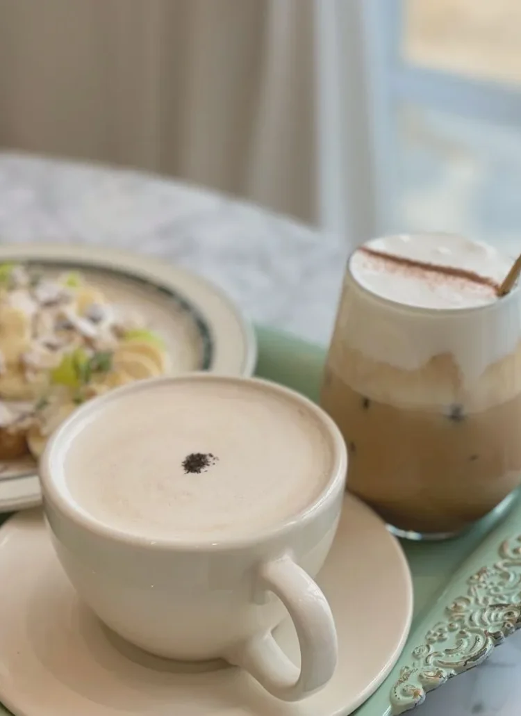 two cups on coffee and a plate of food