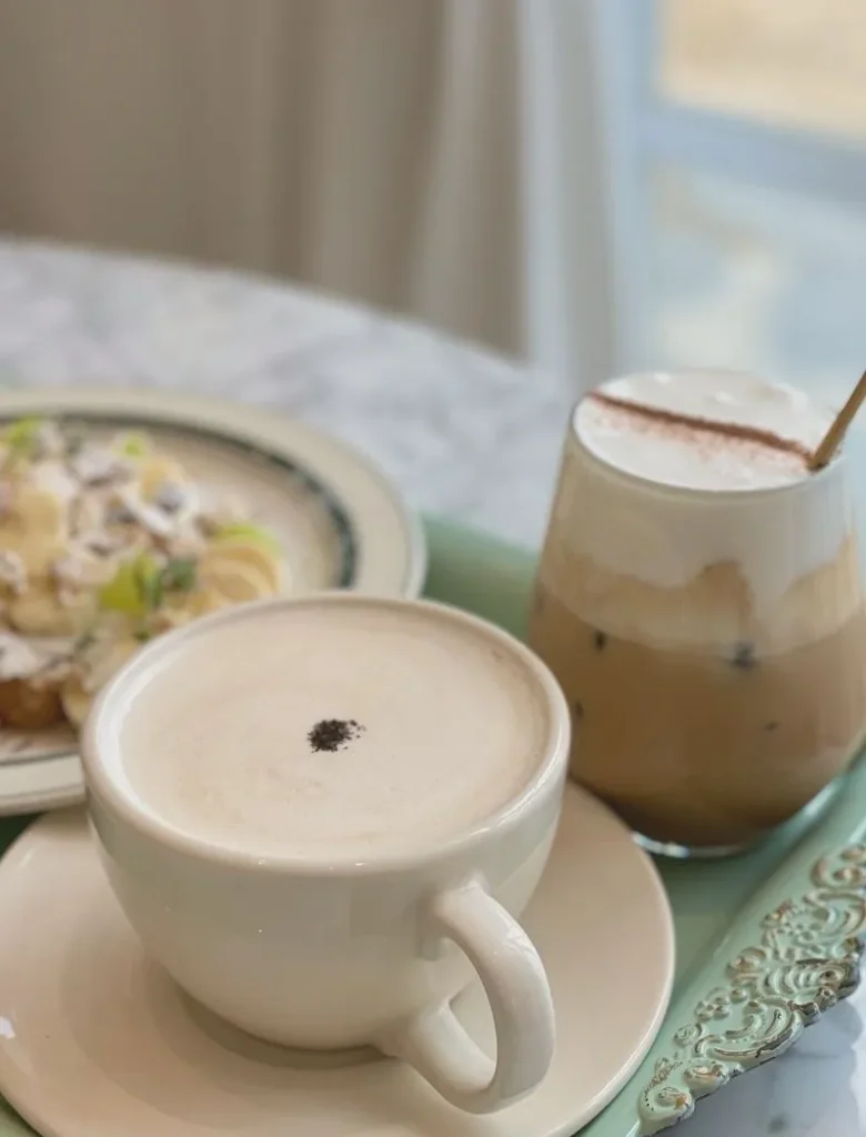 two cups on coffee and a plate of food