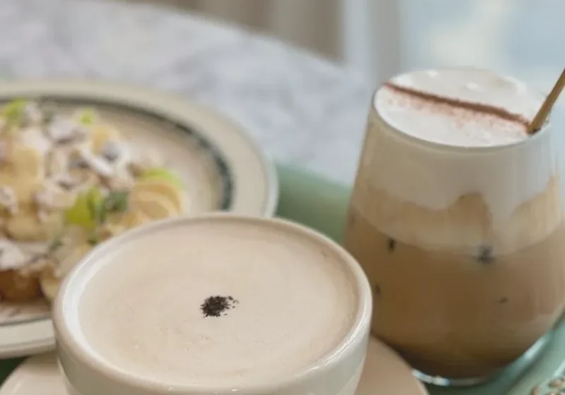 two cups on coffee and a plate of food