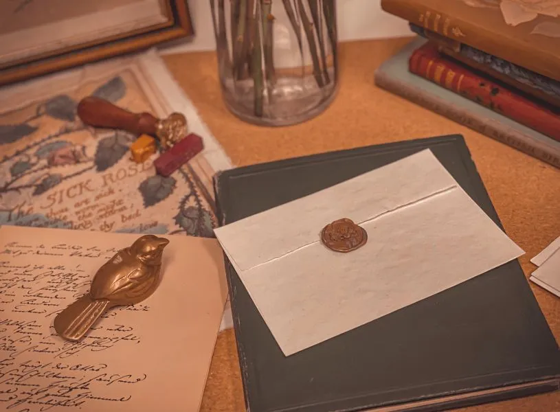 a written letter with a bird paper holder on top and a sealed envelop