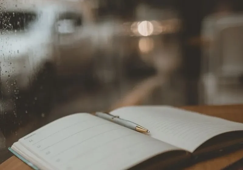 a journal book on a table with pen in the middle of the notebook