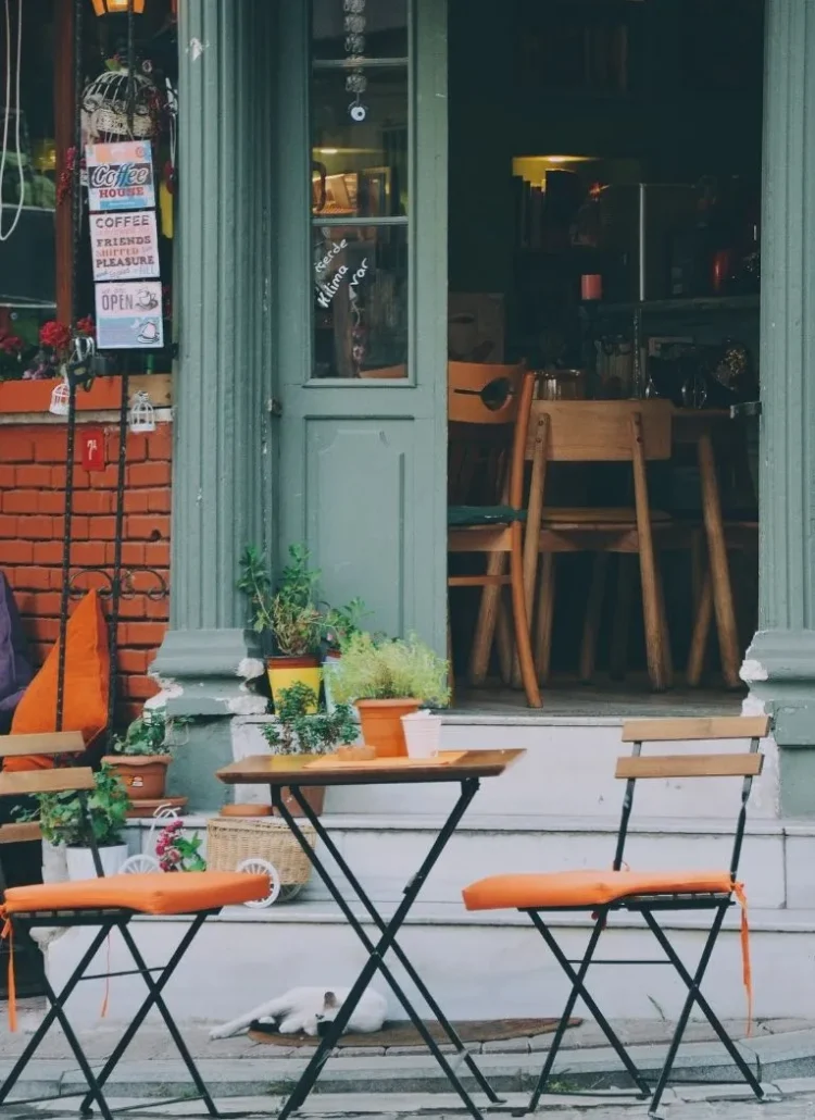 orange chairs and a table in front of a coffee house