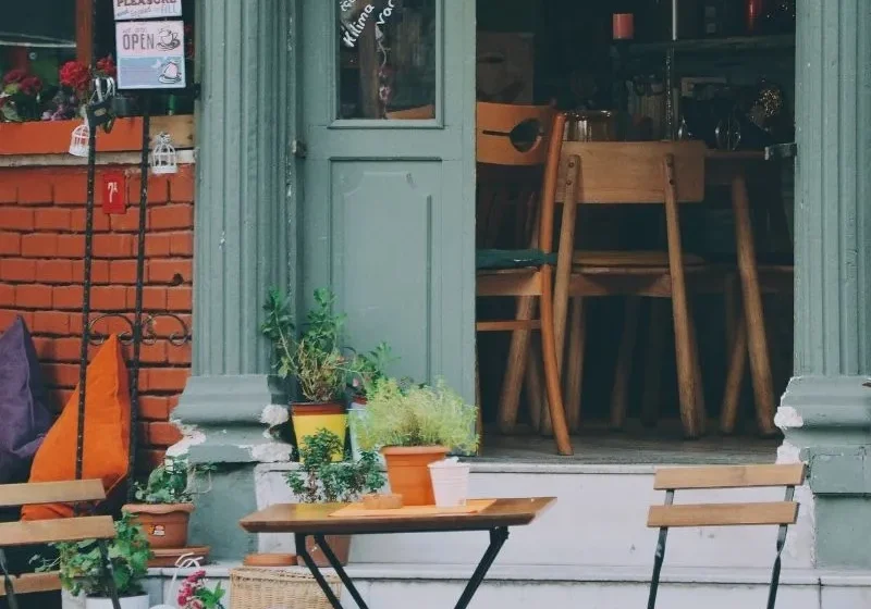 orange chairs and a table in front of a coffee house
