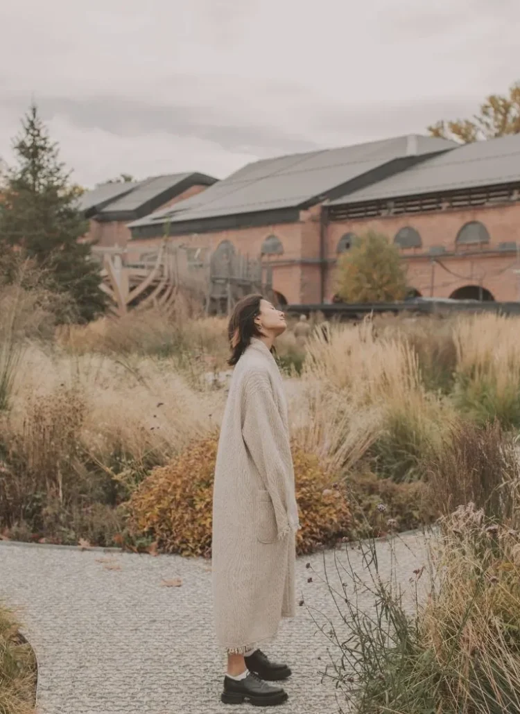 woman standing with her head tilted in the middle of the road