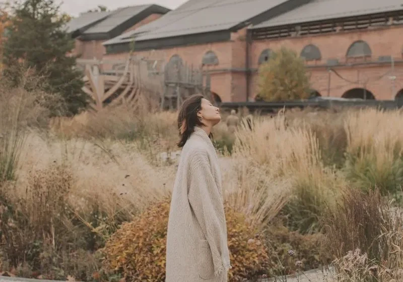woman standing with her head tilted in the middle of the road