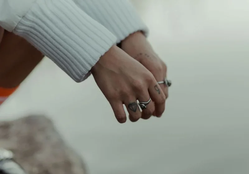 a women's hands with tattoos and rings