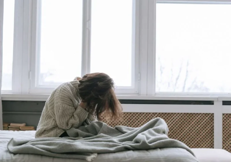an unhappy woman in bed covering her face